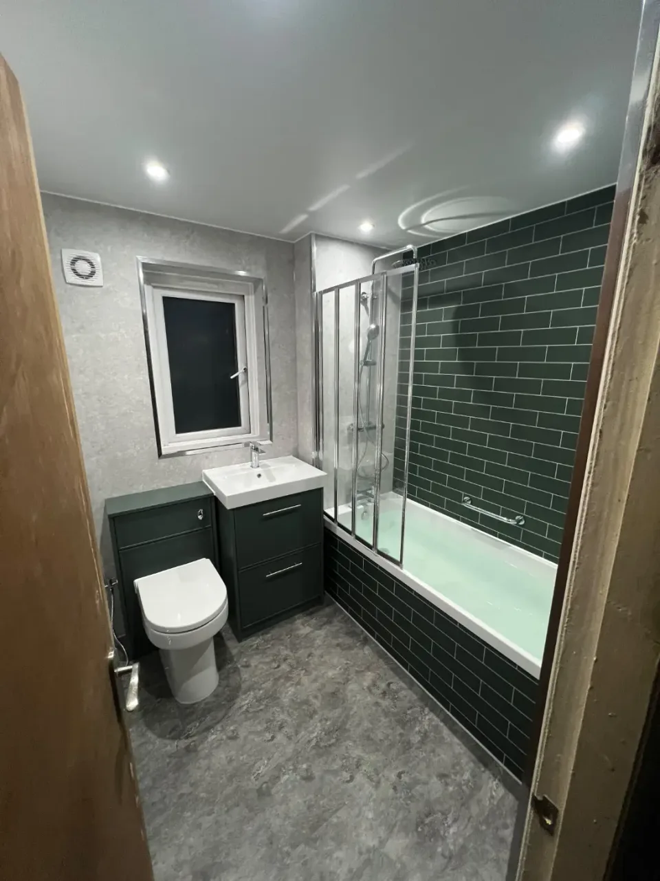 Green wall tiles and a shower-over-bath